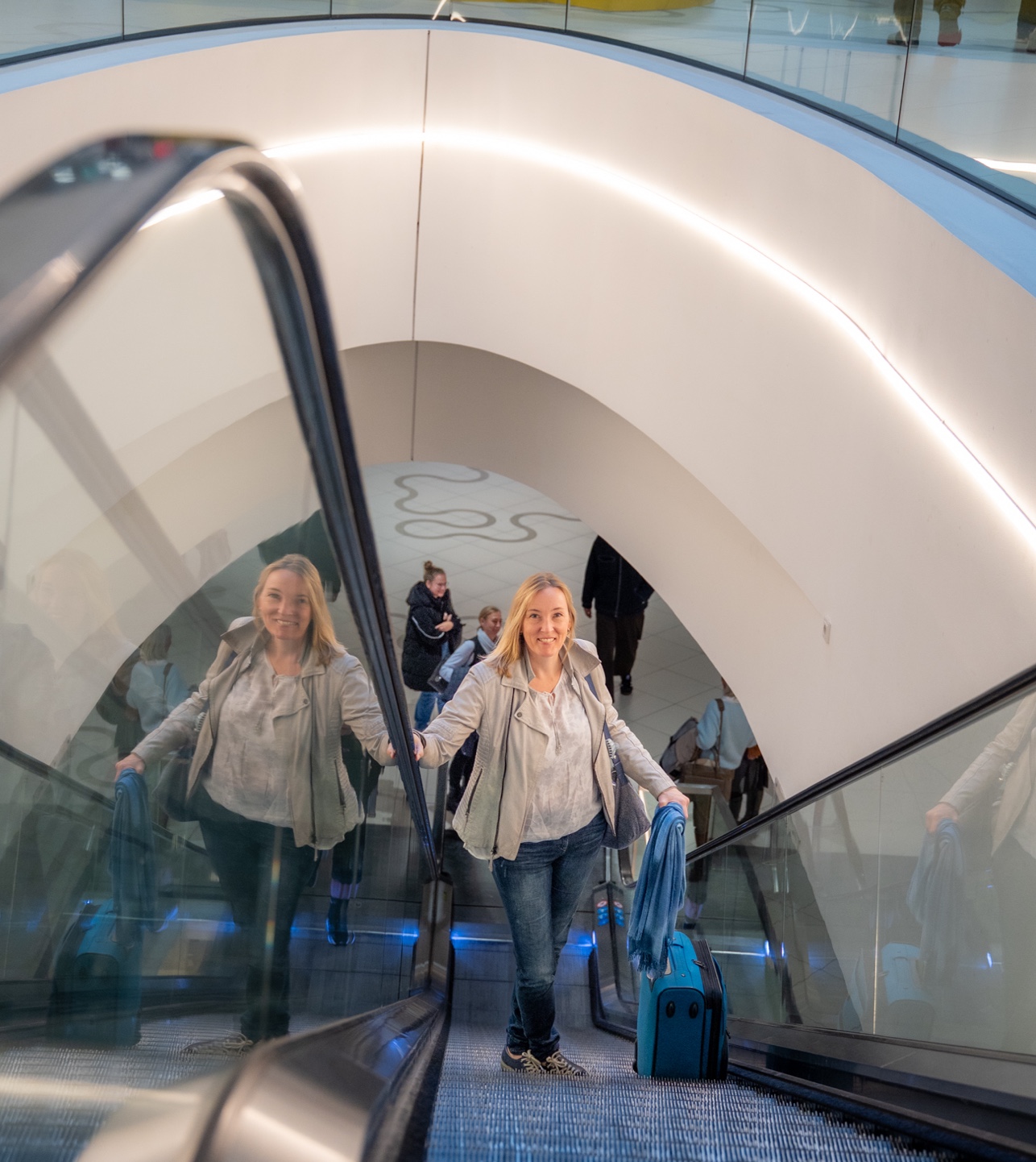 Doris Walla, die Gründerin von Walla Consult, steht auf einer Rolltreppe